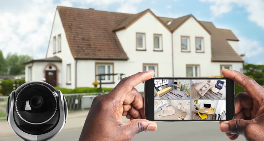 Man holding smartphone and looking at footage from security cameras